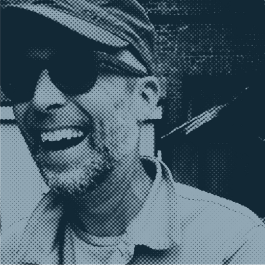 mtthw White male musician wearing dark sunglasses laughing.